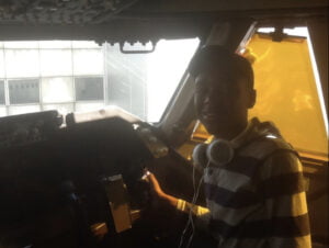 Carlos sitting in the cockpit of a Boeing 747-400 jumbo jet.